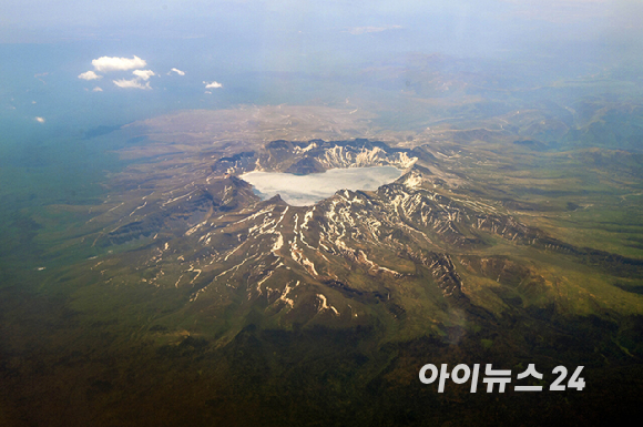 13일 오전 연길공항에서 인천공항으로 가는 비행기 탑승 중 창가에서 바라본 백두산의 모습. [사진=정소희 기자]