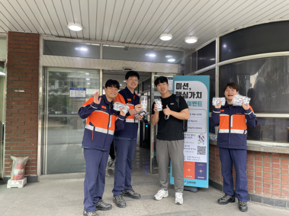 고려아연 직원들이 '미션·핵심가치 퀴즈' 활동에 참여한 뒤 여행용 네임택을 들고 포즈를 취하고 있다. [사진=고려아연]