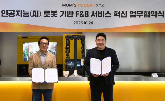 지난 24일 오후 서울 중구 맘스터치 R&D센터에서 맘스터치와 엑스와이지가 'AI·로봇 기반의 F&B 서비스 혁신을 위한 전략적 업무제휴(MOU)'를 체결했다. 김동전(왼쪽) 맘스터치앤컴퍼니 대표이사와 황성재 주식회사 엑스와이지 대표이사가 기념사진을 촬영하고 있다. [사진=맘스터치]