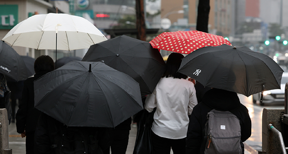 지난 2월 19일 서울 충무로역 인근에서 우산을 쓴 직장인들이 출근길 걸음을 재촉하고 있다. [사진=뉴시스]