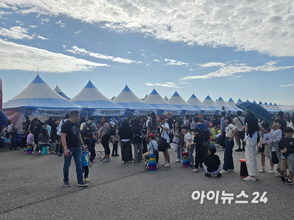 17일 서울공항에서 진행된 서울 국제 항공우주 및 방위산업 전시회(ADEX 2025) 'VR 패러글라이딩 체험존'에 사람들이 줄을 서있다. [사진=최란 기자]