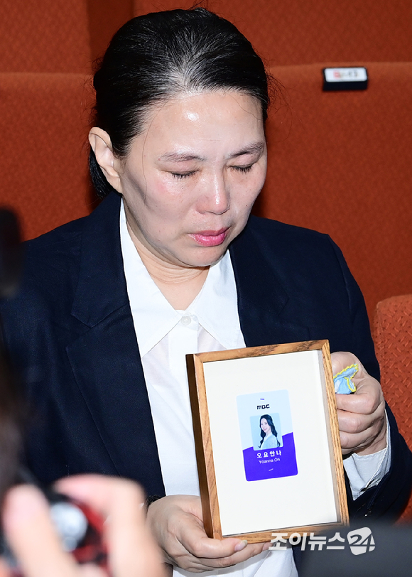 MBC가 15일 오전 서울 상암동 MBC신사옥에서 기상캐스터 故 오요안나의 사망을 둘러싼 직장 내 괴롭힘 의혹에 대한 기자회견을 열었다. 안형준 MBC 사장이 유족과 합의서 전달식을 하고 고인의 어머니 장연미 씨에게 故 오요안나 명예사원증을 전달하고 있다. [사진=정소희 기자]