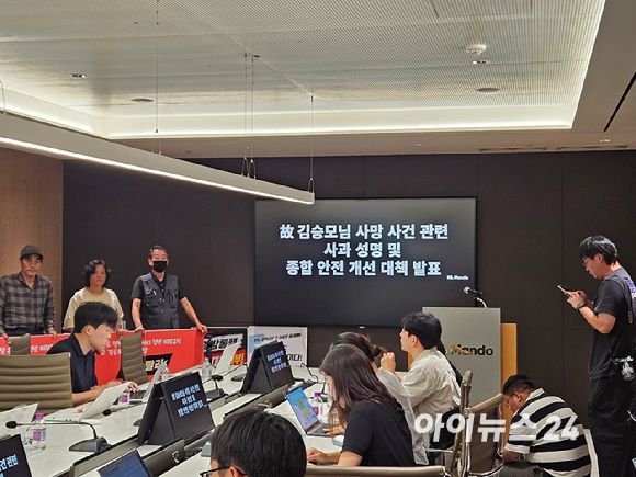 21일 오후 경기 성남시 HL만도 판교 사옥에서 열린 &lsquo;평택공장 사망 사고 관련 종합 안전 개선 대책 발표&rsquo; 기자회견장에서, 고(故) 김승모 군의 유족들이 피켓을 들고 시위를 벌이고 있다. [사진=설재윤 기자]