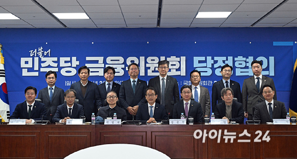 강준현 정무위원회 정조위원장과 이억원 금융위원장을 비롯한 의원들이 19일 국회 의원회관에서 중동사태 속 시장상황 점검 및 민생회복 지원 방안 논의를 위해 열린 더불어민주당 정무위원회-금융위원회 당정협의에서 기념촬영을 하고 있다. [사진=곽영래 기자]