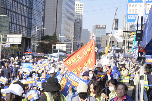 2일 서울역 인근에서 진행된 '김건희·윤석열 국정농단 규탄·특검촉구 국민행동의 날' 집회에 참여한 한 시민이 '탄핵도 사치다. 당선 무효다'라는 깃발을 들어올리고 있다. [사진=김주훈 기자]