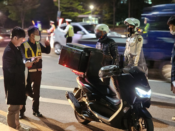 지난 19일 파주경찰서 관계자들이 규정을 위반한 이륜차를 단속하고 있다. [사진=파주경찰서]