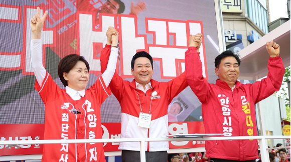 더불어민주당 정청래 총괄상임선거대책위원장이 22일 민주당 우상호 강원도지사 후보&middot;김중남 강릉시장 후보와 강원 강릉시 주문진시장을 방문해 오징어를 구입하고 있다. [사진=연합뉴스]