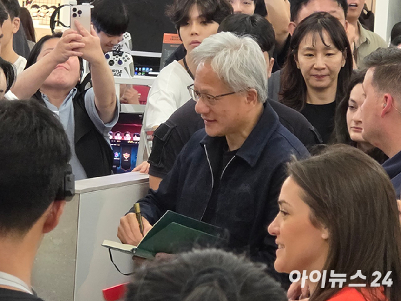 젠슨 황 엔비디아 최고경영자(CEO)가 5일 서울 마포구 &lsquo;T1 베이스 캠프&rsquo;를 방문해 &lsquo;페이커&lsquo; 이상혁을 비롯한 e스포츠 구단 T1의 리그 오브 레전드(LoL) 선수단을 만난 뒤 페이커 선수에게 받은 유니폼을 꺼내보고 있다. [사진=곽영래 기자]