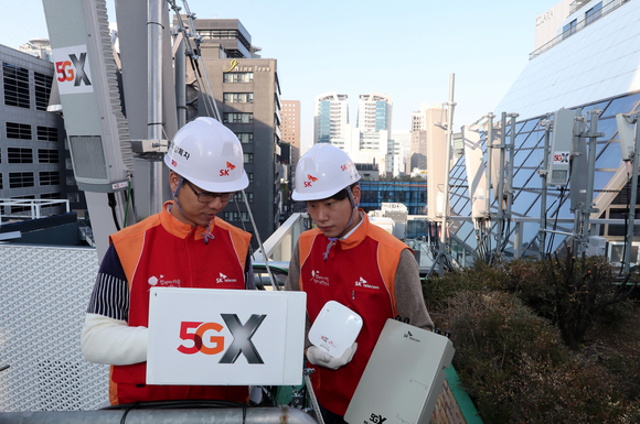 서울 중구 명동 한 빌딩 옥상에서 SK텔레콤 직원들이 5G 기지국을 설치하고 있는 모습.  [사진=SKT]