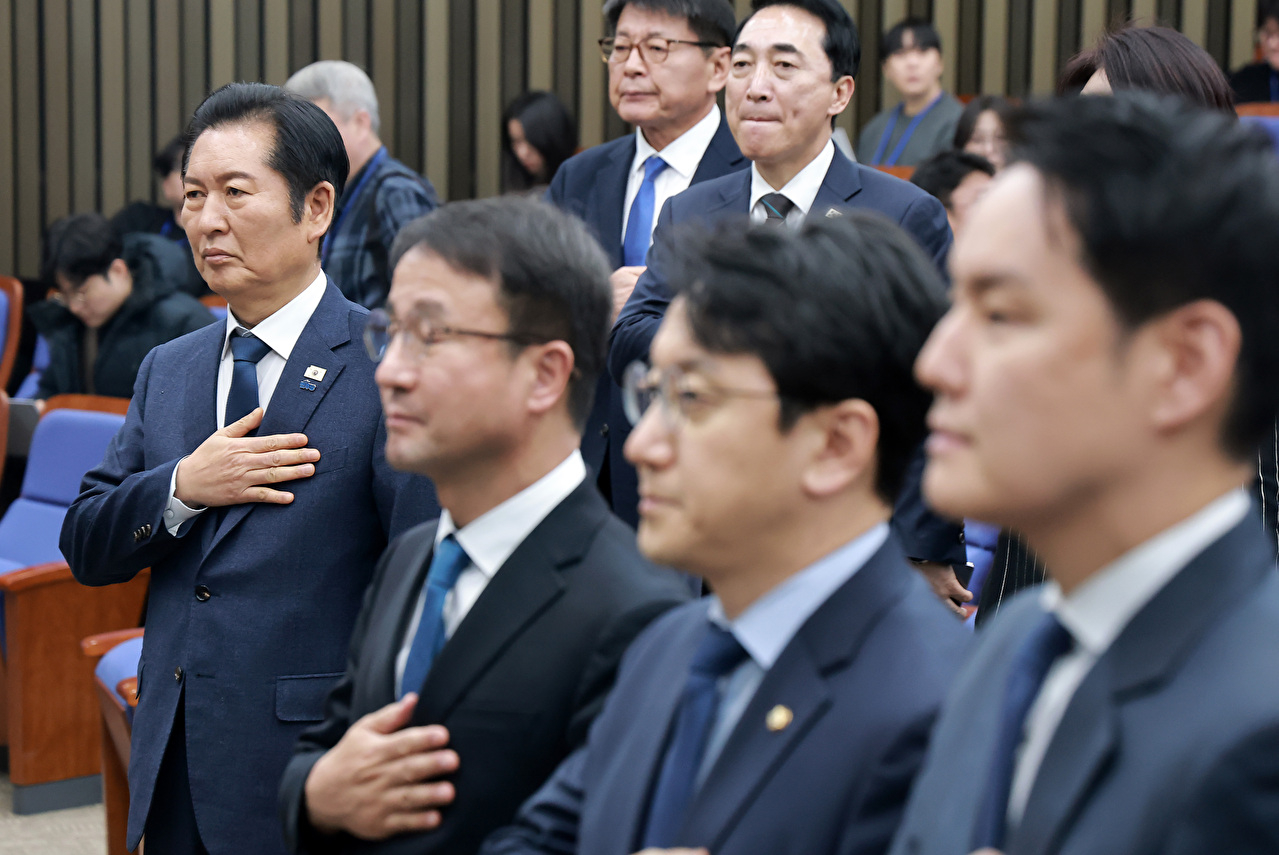 더불어민주당 정청래 대표를 비롯한 참석 의원들이 15일 국회에서 열린 의원총회에서 국기에 경례하고 있다. 2026.1.15 [사진=연합뉴스]