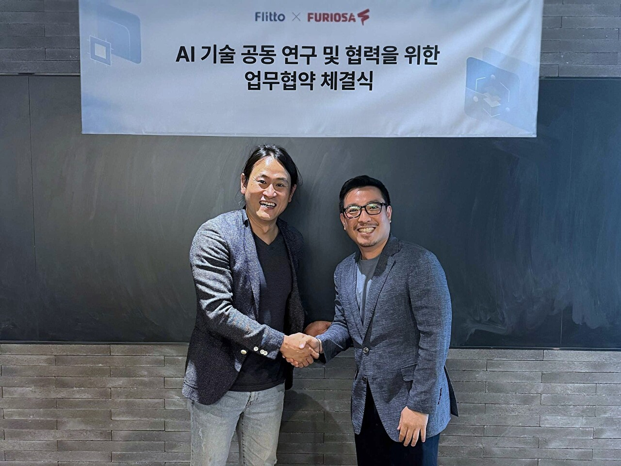 백준호 퓨리오사AI 대표(왼쪽)와 이정수 플리토 대표가 업무 협약 체결 후 악수하고 있다. [사진=플리토]