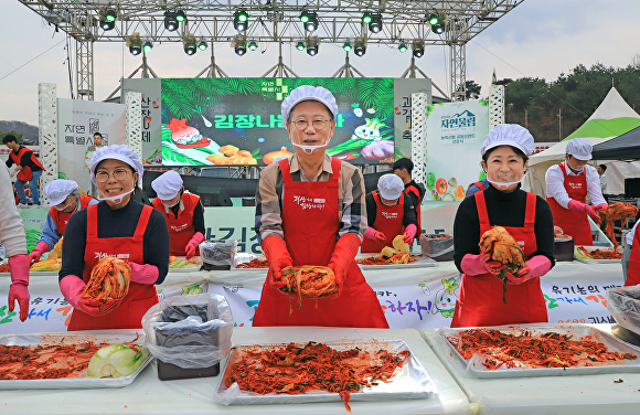 2023괴산김장축제장에서 송인헌(가운데) 군수가 직접 담근 김장을 들어보이고 있다. [사진=괴산군]