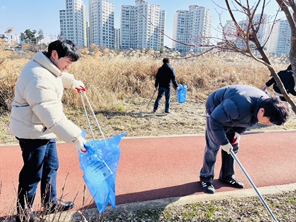 청주시 차량등록사업소 직원들과 충북자동차매매사업조합이 8일 청주 무심천 일원에서 환경정화활동을 하고 있다. [사진=청주시]