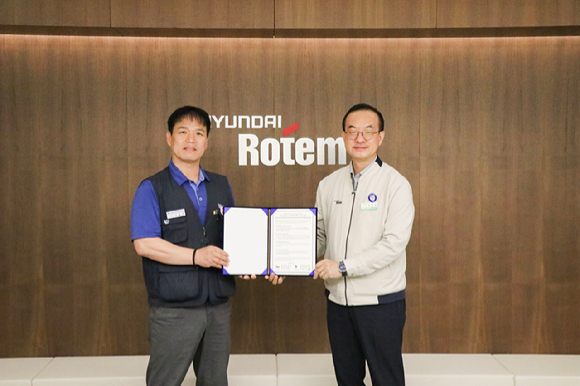 김익수(오른쪽) 현대로템 경영지원본부장과 남봉희 전국금속노동조합 현대로템 지회장이 지난 19일 현대로템 창원공장에서 열린 동반성장 노사미래전략TFT 발족식에서 기념촬영을 하고 있다. [사진=현대로템]