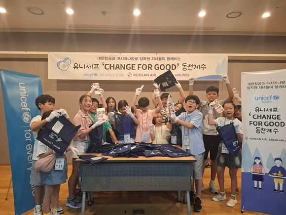 아시아나항공과 대한항공 임직원 자녀들이 ‘사랑의 기내 동전 모으기 캠페인’으로 모인 동전을 계수하는 봉사 활동을 하고 있다. [사진=아시아나항공]
