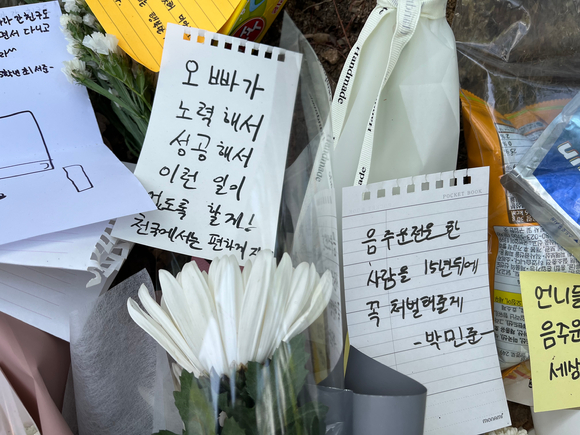 지난달 10일 오전 대전 서구 둔산동의 한 초등학교 인근에 음주운전 사고로 사망한 9살 초등학생을 추모하기 위한 쪽지가 꽃과 함께 놓여있다. [사진=뉴시스]