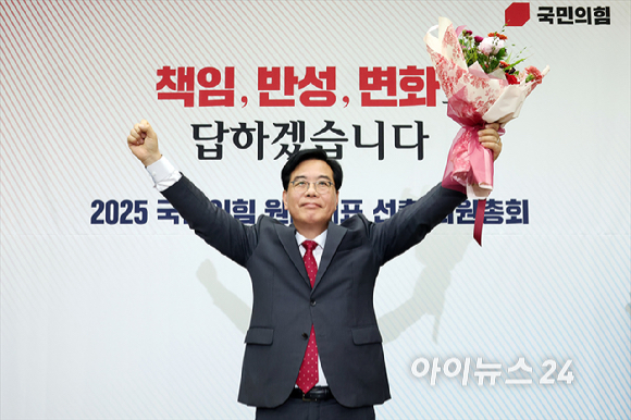 송언석 국민의힘 신임 원내대표가 16일 오후 서울 여의도 국회에서 열린 2025 국민의힘 원내대표 선출 의원총회에서 꽃다발을 든 채 손을 들어올리고 있다. [사진=곽영래 기자]