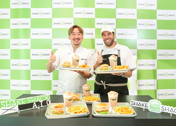 박정현 셰프(왼쪽)와 마크 로사티 쉐이크쉑 컬리너리 디렉터가 신규 이전한 쉐이크쉑 강남대로점에서 '아토 메뉴 3종'을 소개하고 있다. [사진=쉐이크쉑]