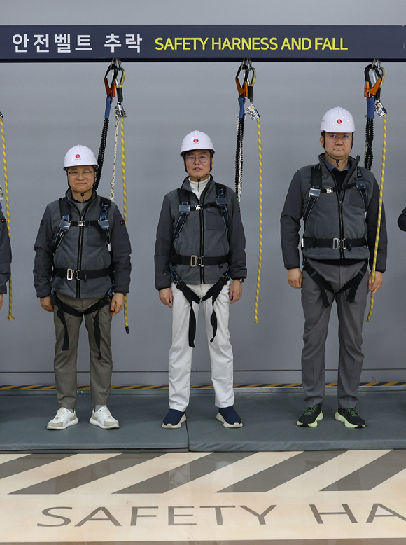 오일근 롯데건설 대표(사진 왼쪽에서 두 번째)가 27일 오산 롯데인재개발원에서 진행된 경영진 안전체험교육에 참여해 안전벨트 추락 체험을 하고 있다. [사진=롯데건설]