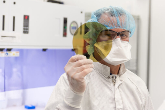 SK실트론 직원이 SiC 웨이퍼를 들고 있는 모습. [사진=SK실트론 ]