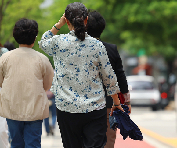 초여름 날씨를 보인 20일 서울 청계천에서 시민들이 외투를 팔에 걸고 산책을 즐기고 있다. [사진=연합뉴스]