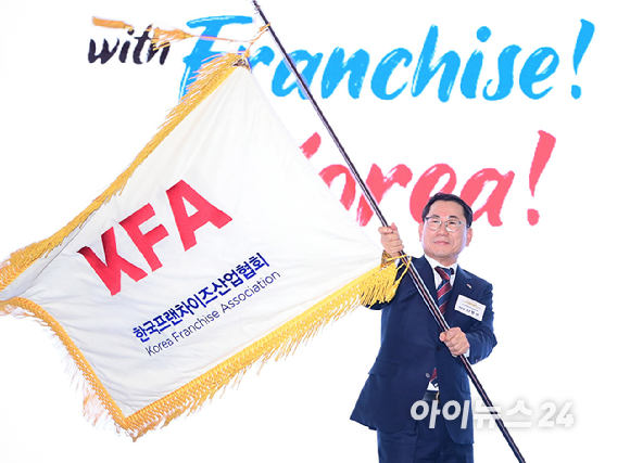 나명석 신임 한국프랜차이즈산업협회장(웰빙푸드 회장)이 19일 오후 서울 여의도 콘래드 서울 그랜드볼룸에서 열린 한국프랜차이즈산업협회 협회장 이&middot;취임식 및 비전 선포식에서 협회기를 흔들고 있다. [사진=정소희 기자]