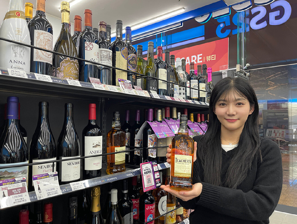 GS25에서 출시 후 품절대란을 일으킨 1만원대 가성비 위스키 티처스 상품을 들고 포즈를 취하고 있는 모습. [사진=GS25]