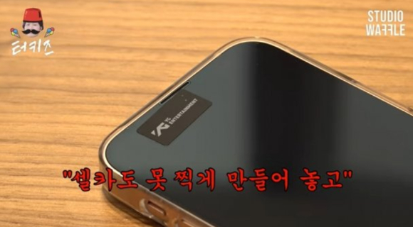 YG 측은 사옥에 방문한 이용진과 촬영팀 전원에게 휴대폰 카메라에 '보안 스티커'를 부착할 것을 요구했다. [사진=유튜브 '스튜디오 와플']