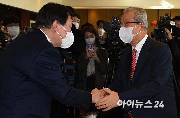 국민의힘 윤석열 대선후보와 김종인 전 비상대책위원장이 15일 서울 용산구 그랜드 하얏트 서울 호텔에서 열린 만화로 읽는 오늘의 인물이야기 '비상대책위원장-김종인' 출판기념회에서 악수하고 있다. [사진=국회사진취재단]