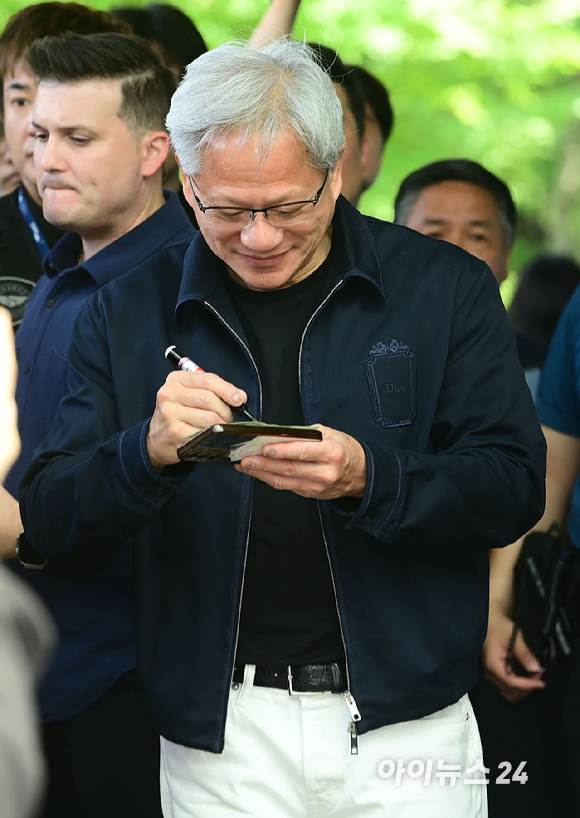 젠슨 황 엔비디아 최고경영자(CEO)가 5일 오후 전세기를 통해 서울김포비즈니스항공센터로 입국해 시민들의 사인 요청에 응하고 있다. 한 시민이 만원권 지폐에 사인을 요청하자 주머니에 넣을려는 유머스러운 제스쳐을 하며 웃는 젠슨 황의 모습. [사진=정소희 기자]