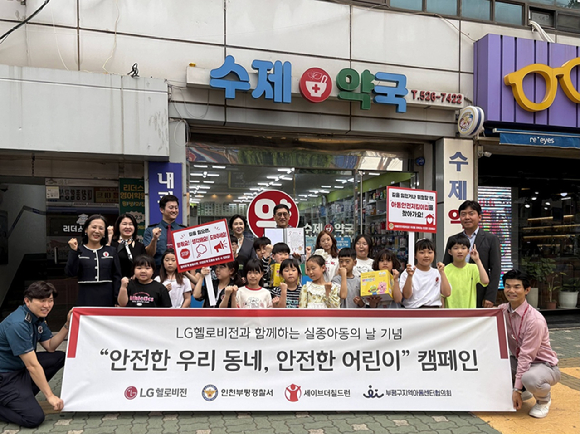 지난 19일 인천 부평구 소재 한 아동안전지킴이집(수제약국) 앞에서 관계자들과 지역아동센터 아이들이 아동 안전망 구축을 다짐하며 단체 기념촬영을 하고 있는 모습. [사진=LG헬로비전]