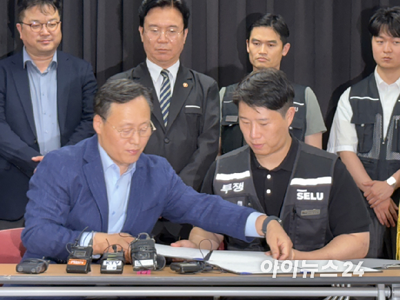 여명구 삼성전자 부사장(왼쪽)과 최승호 초기업노조 위원장이 20일 수원 경기고용노동청에서 열린 성과급 제도 개편에 합의하고 서명하고 있다. [사진=권서아 기자]