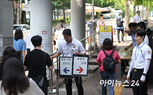 24일 윤석열 전 대통령의 내란 우두머리 혐의 관련 재판 12차 공판 기일이 열리는 서울 서초구 서울중앙지방법원 입구에 법원 보안 인력이 배치되어 있다.윤 대통령은 이날 재판부에 건강상의 사유로 출석하기 어렵다는 내용의 의견서를 제출하며 재판에 불출석했다. [사진=사진공동취재단]