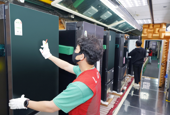 LG전자 직원들이 경남 창원시에 있는 김치냉장고 생산라인에서 '디오스 김치톡톡 오브제컬렉션'의 외관, 기능, 소음 등을 검사하고 있다. [사진=LG전자]