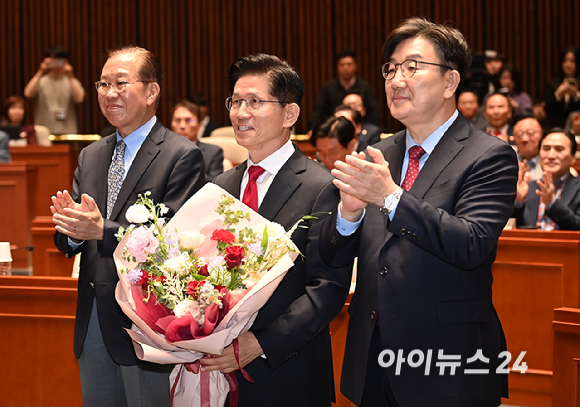 김문수 국민의힘 대선후보가 9일 서울 여의도 국회에서 열린 의원총회에서 꽃다발을 들고 권영세 비대위원장, 권성동 원내대표와 기념촬영을 하고 있다. [사진=곽영래 기자]