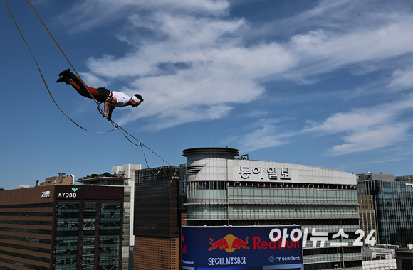 세계적인 슬랙라인 선수 얀 루스(Jaan Roose)가 1일 서울 광화문 사거리 상공 120m 높이에서 '레드불 서울 줄타기' 퍼포먼스를 선보이고 있다. [사진=정소희 기자]