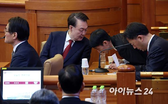 윤석열 대통령이 11일 서울 종로구 헌법재판소에서 열린 탄핵심판 7차 변론기일에 출석해 변호인과 대화하고 있다. [사진=사진공동취재단]