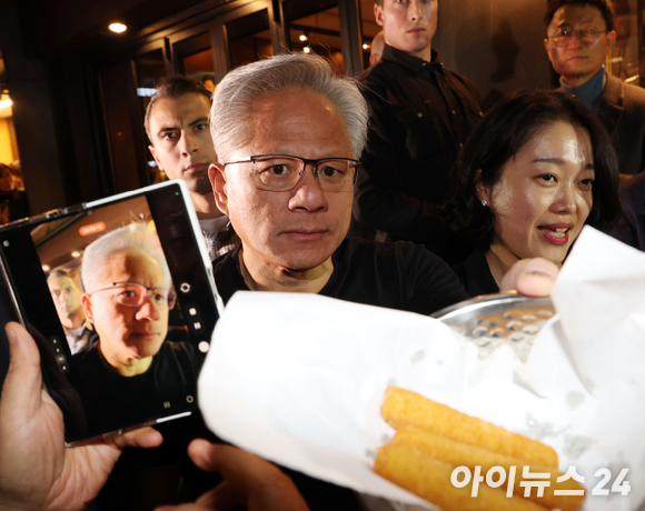 젠슨 황 엔비디아 최고경영자가 지난해 10월 30일 서울 삼성동 한 치킨집에서 진행된 이재용 삼성전자 회장, 정의선 현대차그룹 회장과 치맥 회동 중 시민과 취재진에게 감자튀김을 나눠주고 있다. [사진=사진공동취재단]