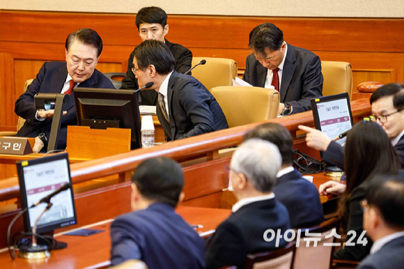 윤석열 대통령이 11일 오전 서울 종로구 헌법재판소에서 열린 윤석열 대통령 탄핵 심판 7차 변론기일에 출석해 배보윤 변호사와 대화를 나누고 있다. [사진=사진공동취재단]