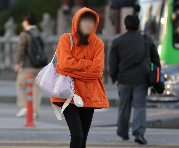 서울 종로구 광화문광장에서 겉옷을 걸친 한 시민이 발걸음을 재촉하고 있다. [사진=연합뉴스]