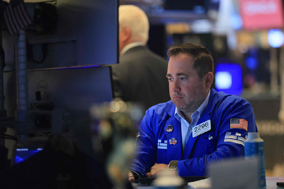 뉴욕증권거래소(NYSE) 트레이더가 거래 화면을 살펴보고 있다. [사진=AFP/연합뉴스]