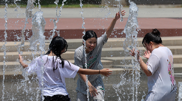 지난 21일 오후 서울 영등포구 여의도한강공원 물빛광장을 찾은 학생들이 물놀이를 하고 있다. [사진=뉴시스]