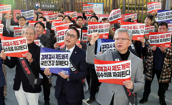 김택우 대한의사협회 회장(오른쪽)을 비롯한 의사들이 11일 정부세종청사 보건복지부 앞에서 열린 '검체검사 제도개편 강제화 전면 중단 촉구 대표자 궐기대회'에서 구호를 외치고 있다. [사진=연합뉴스]