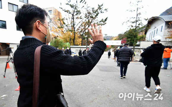 2022학년도 대학수학능력시험일인 18일 서울 종로구 경복고등학교에서 수험생들이 시험장으로 향하고 있는 가운데 학부모가 손을 흔들고 있다. [사진=사진공동취재단]