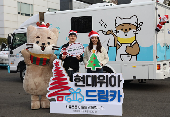 현대위아 직원들이 지난 23일 경상남도 창원시 현대위아 본사 앞에서 지역 사회복지기관 10곳에 선물할 &lsquo;현대위아 드림카&rsquo;와 함께 기념 사진을 찍고 있다. [사진=현대위아]