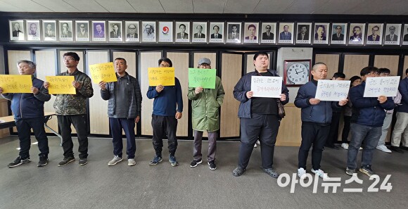  18일 오전 김윤철 경남 합천군수의 기자회견이 열리고 있는 합천군청 대회의실에 지역 주민 10여명이 손피켓을 들고 항의하고 있다. [사진=임승제 기자] 