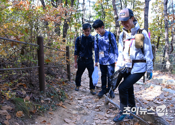 29일 서울 은평구 북한산 원효능선에서 진행된 '산악인 오은선과 함께 하는 제6회 희망찾기 등산·트레킹 교실'에서 참가자들이 플로깅을 하고 있다. [사진=김성진 기자]