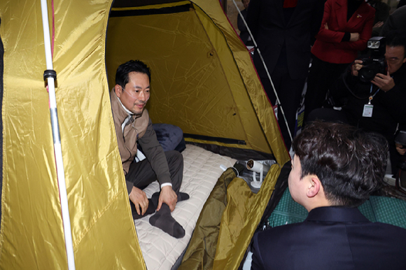 통일교&middot;공천헌금 '쌍특검' 수용을 요구하며 단식 7일 차를 맞은 국민의힘 장동혁 대표가 21일 국회 로텐더홀 단식 농성장을 찾은 개혁신당 이준석 대표와 대화하고 있다. [사진=연합뉴스]