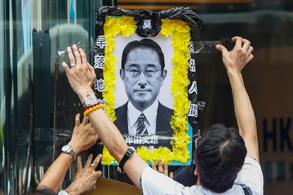 일본의 후쿠시마 원전 오염수 해양 방류에 항의하는 홍콩 시위대가 기시다 후미오 일본 총리를 아돌프 히틀러로 묘사한 영정 사진을 벽에 붙이고 있다. [사진=AP/뉴시스]