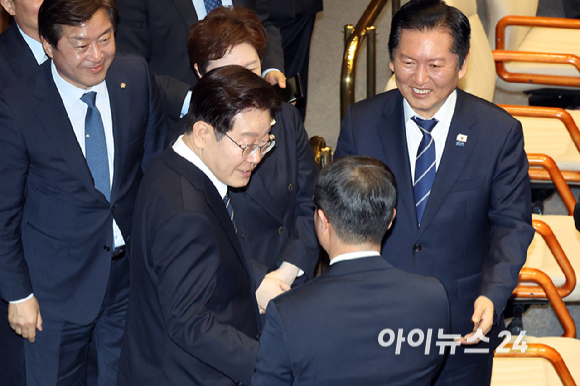 이재명 대통령이 2일 서울 여의도 국회 본회의장에서 중동 사태 대응 등을 위한 추가경정예산안에 대한 시정연설에 앞서 더불어민주당 의원들과 악수를 하고 있다. [사진=곽영래 기자]